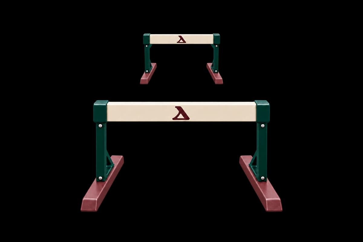 Two matching Cleats hurdles facing forward, centred in one straight lane with their feet inside its boundaries